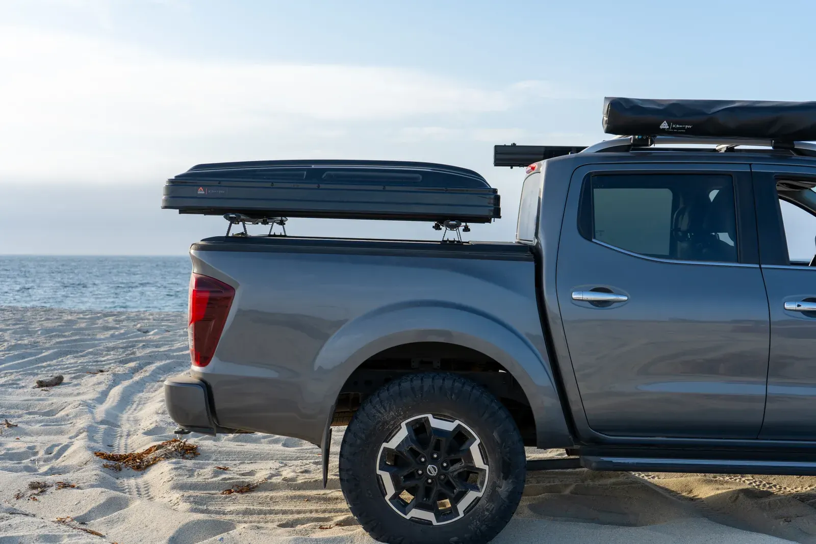 Camioneta con carpa de techo cerrada en la playa