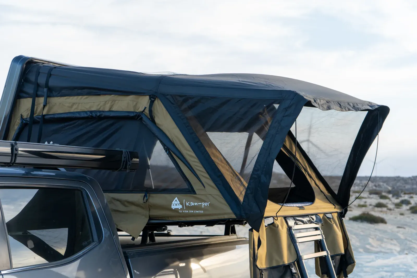 Carpa Kam-per abierta sobre una camioneta en la playa