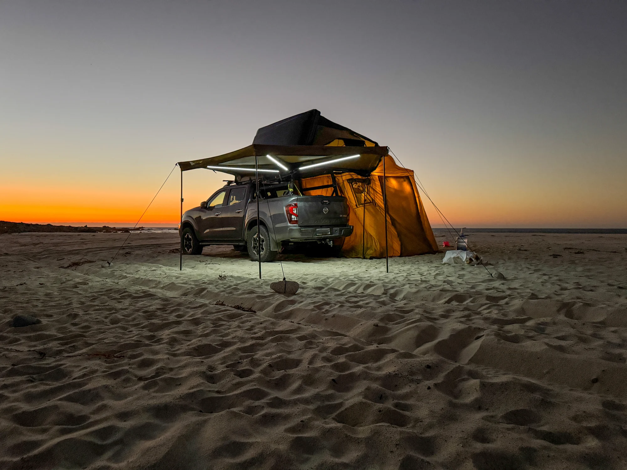 Vehículo Kam-per con equipamiento de camping al atardecer